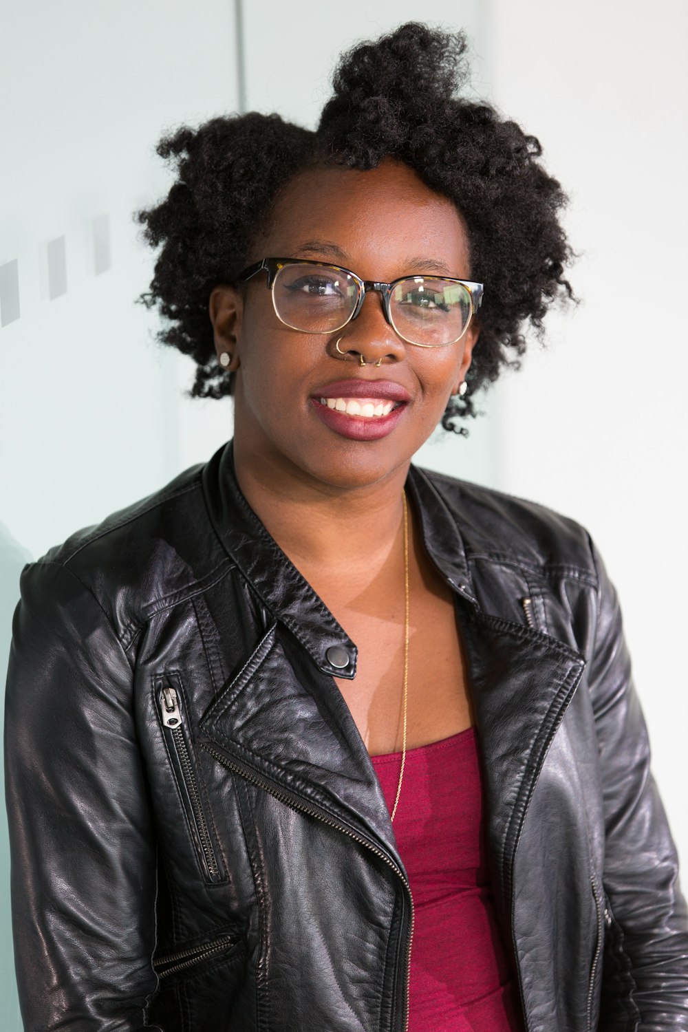 a woman wearing glasses and a leather jacket