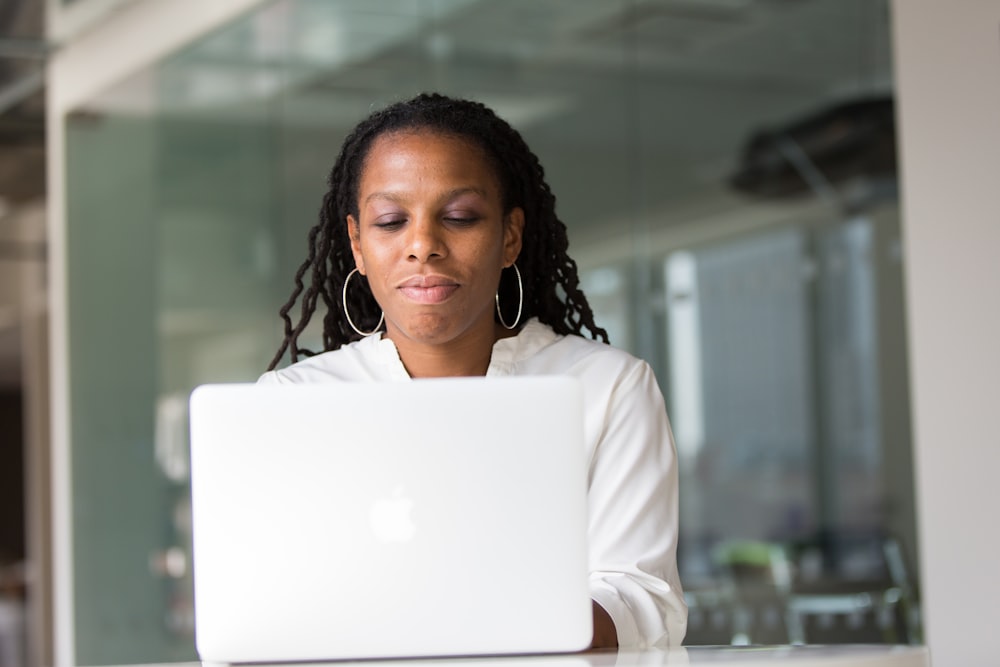 woman wearing white top using MacBook