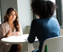 two women sitting on chair