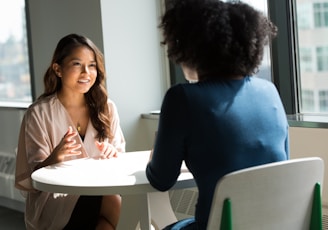 two women sitting on chair