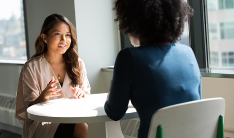 two women sitting on chair