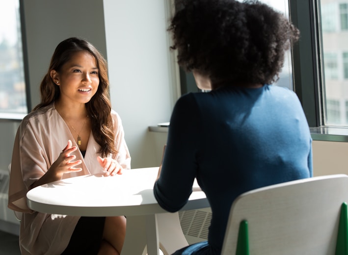 two women sitting on chair