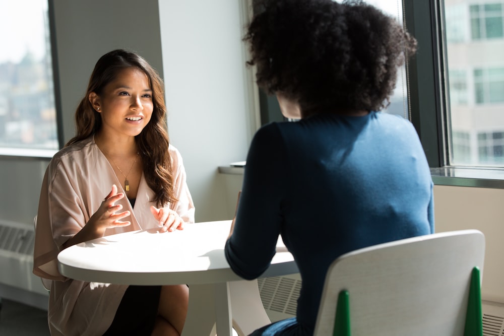 two women sitting on chair