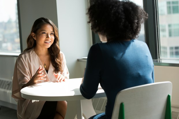 Two women in conversation at a small table