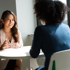 two women sitting on chair