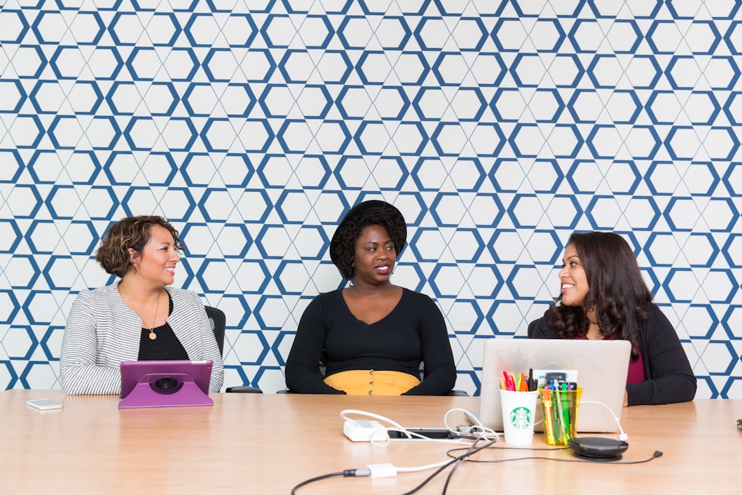 three women sitting on chairs front of table,