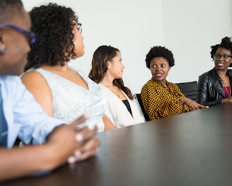 five people sitting at table and talking