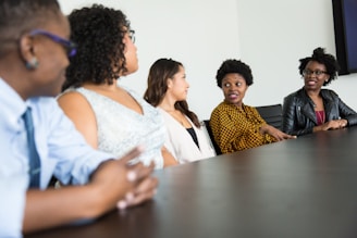 five people sitting at table and talking