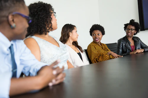 A diverse group of people in a mentoring discussion around a table