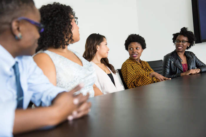 Five colleagues sitting at a table talking together