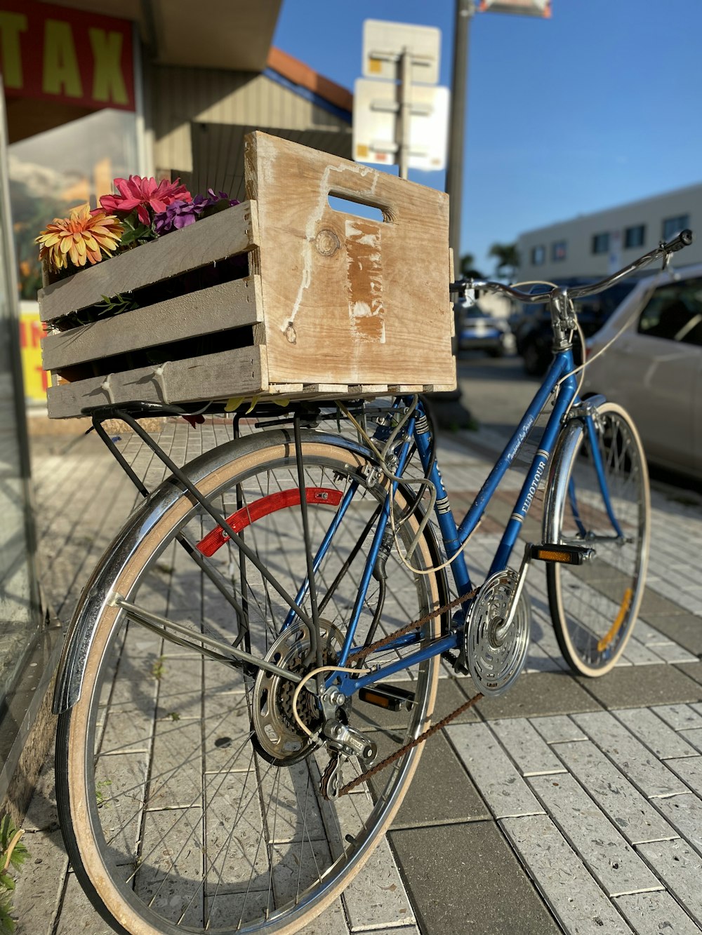 blue city bike carrying brown wooden crate