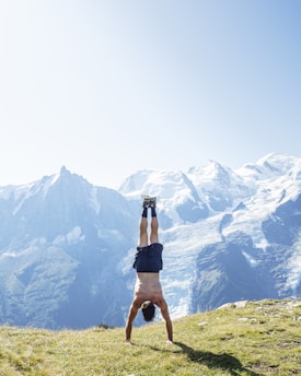 man wearing blue short doing hand stand