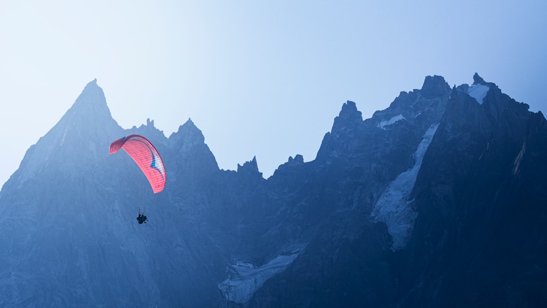 person parachuting near mountains
