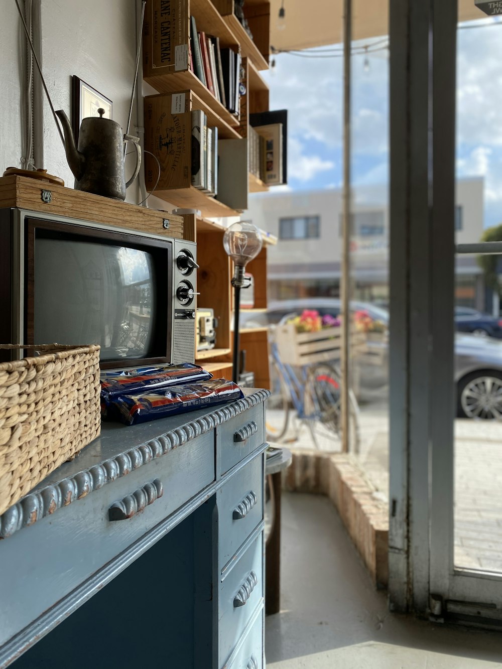 brown and black CRT television on wooden dresser