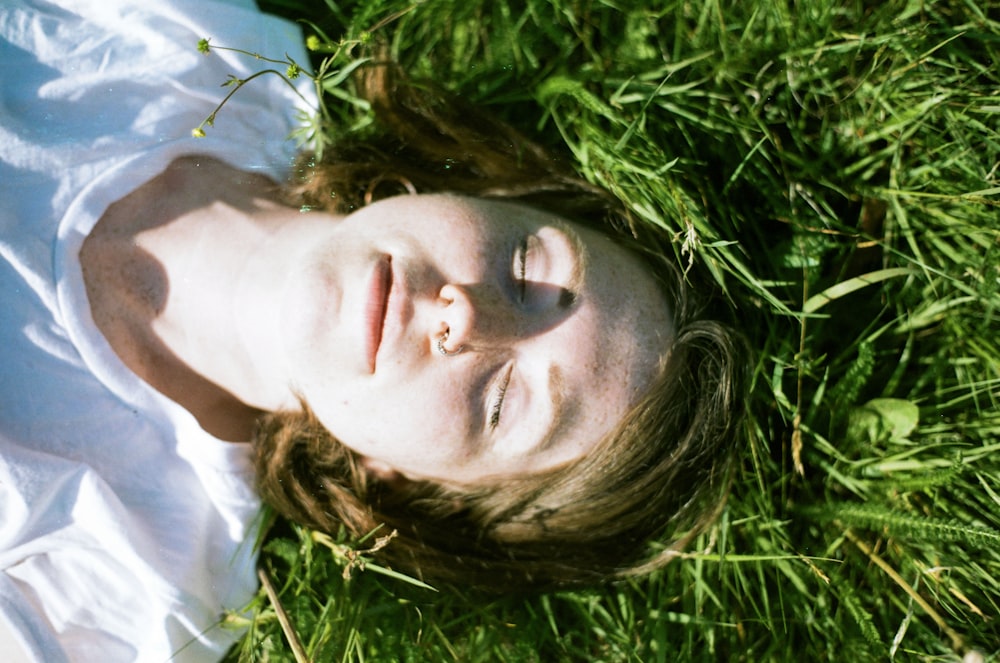 femme couchée sur l’herbe verte