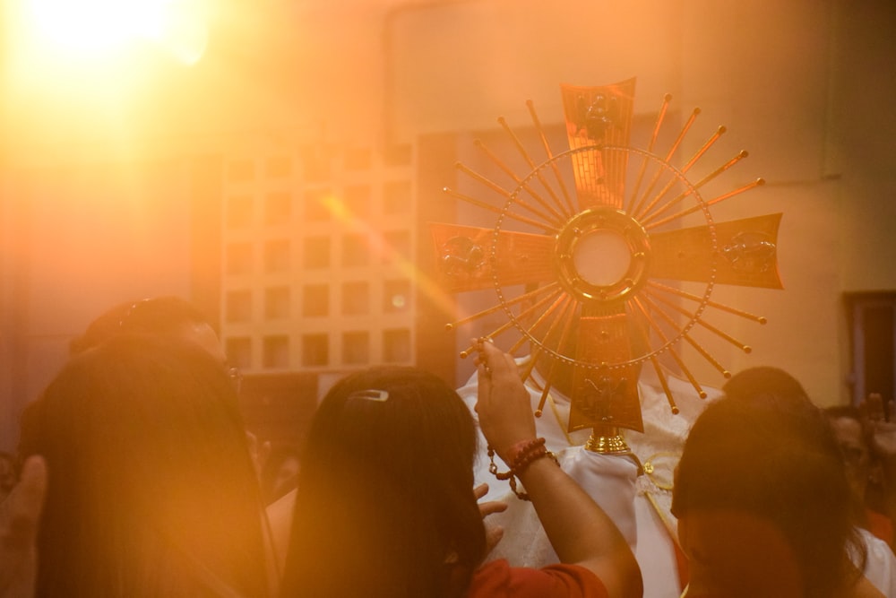 people standing beside gold cross