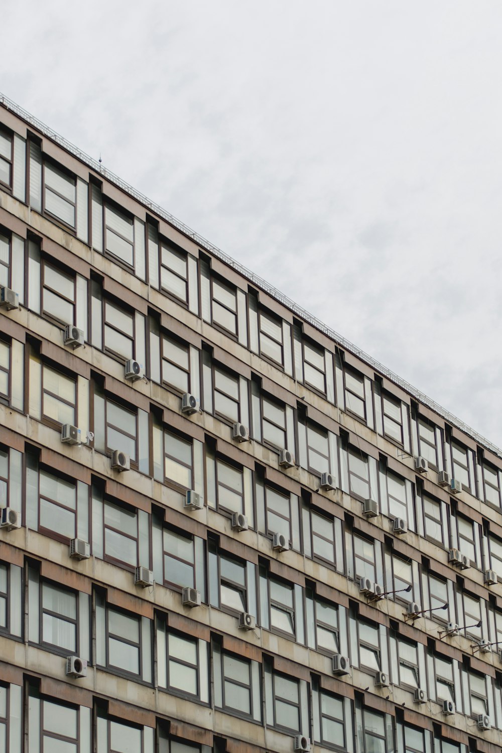 Edificio marrón y gris bajo nubes blancas