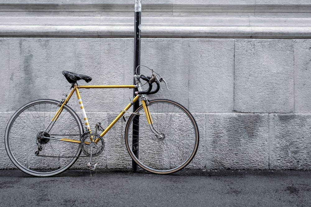yellow road bike parked beside wall