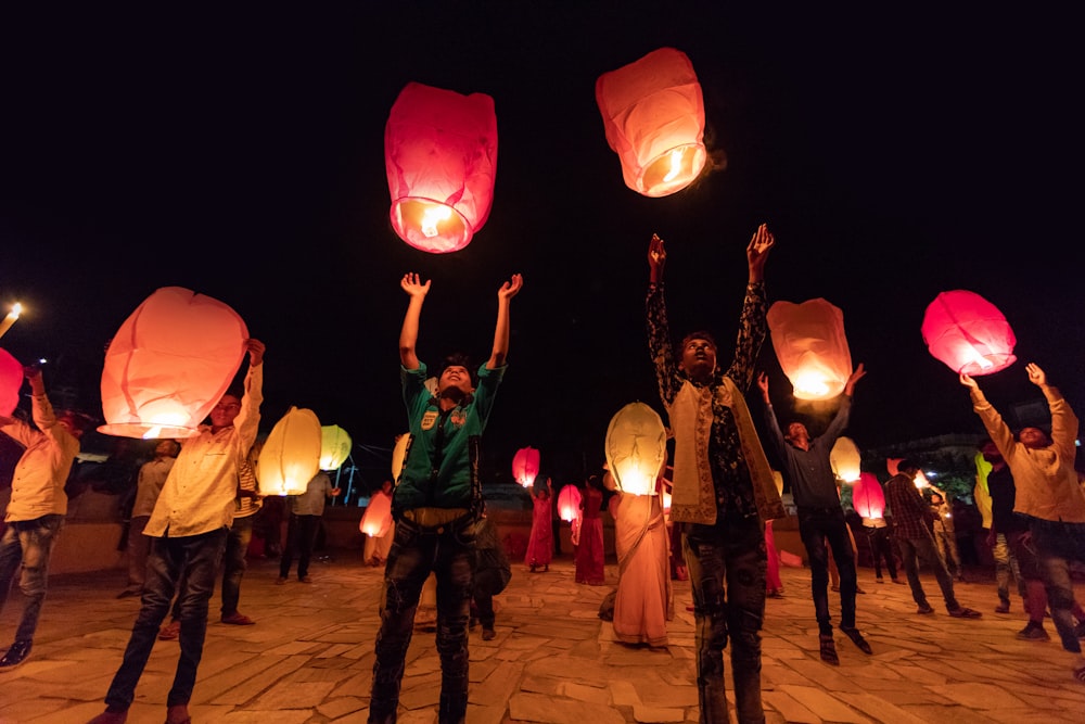 people holding flying lanterns