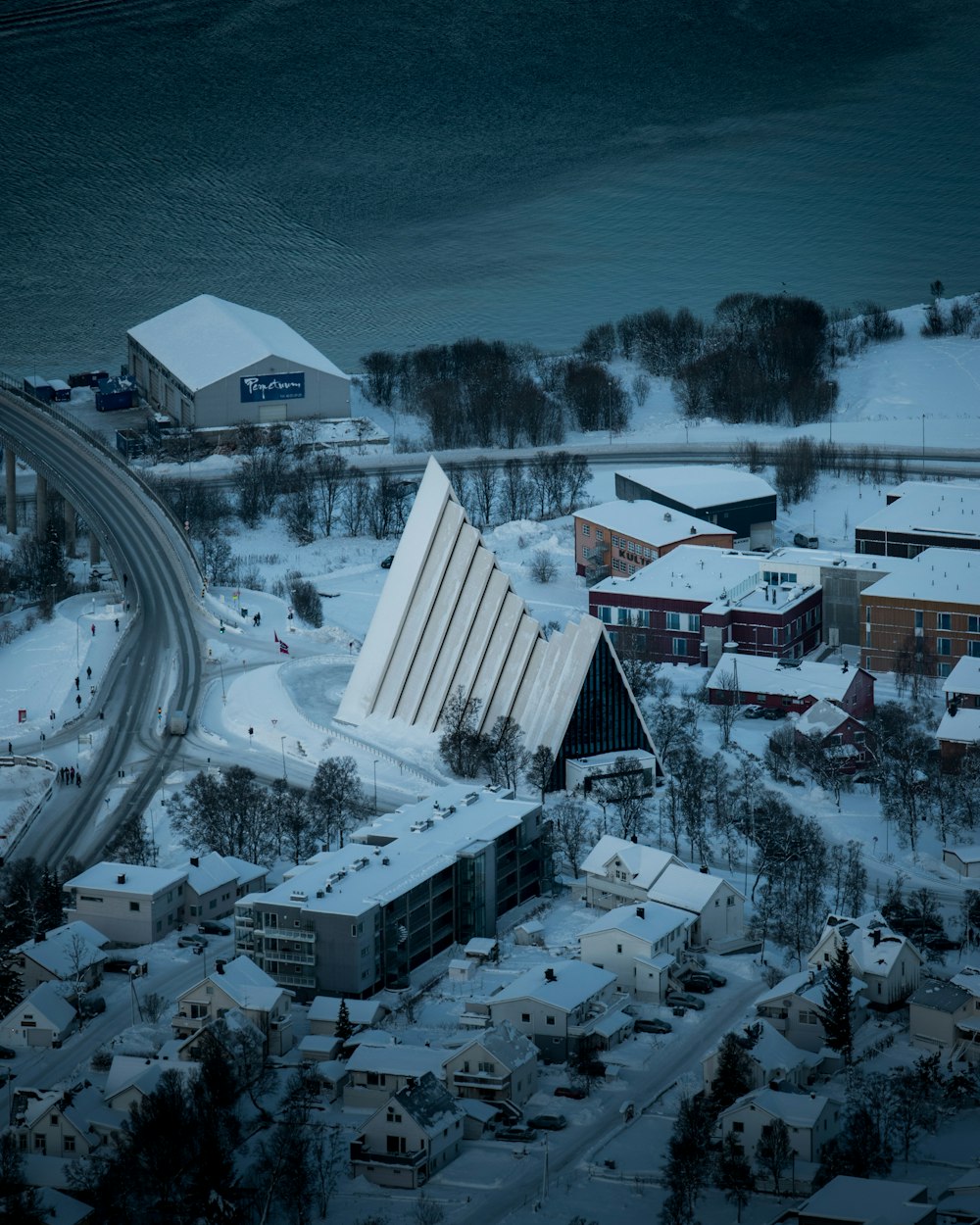 aerial photography of houses covered with snow near body of water during daytime