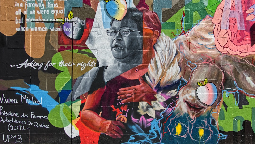a wall with a painting of a man and a woman on it, Peinture murale représentant Viviane Michel sur la rue Sainte-Catherine.<p></figure>