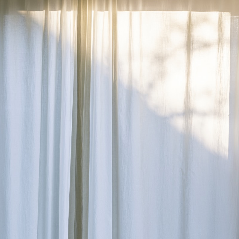 Lumière douce du matin filtrant à travers des rideaux blancs