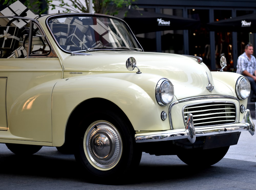 classic beige vehicle parked beside sidewalk