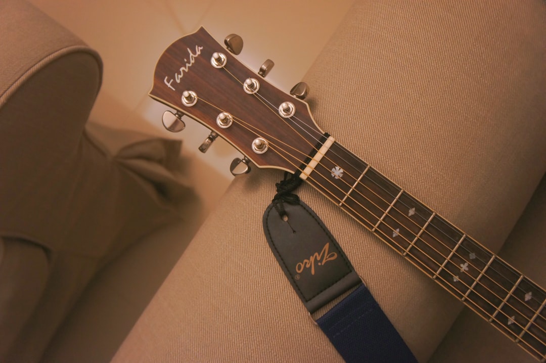 brown guitar on sofa