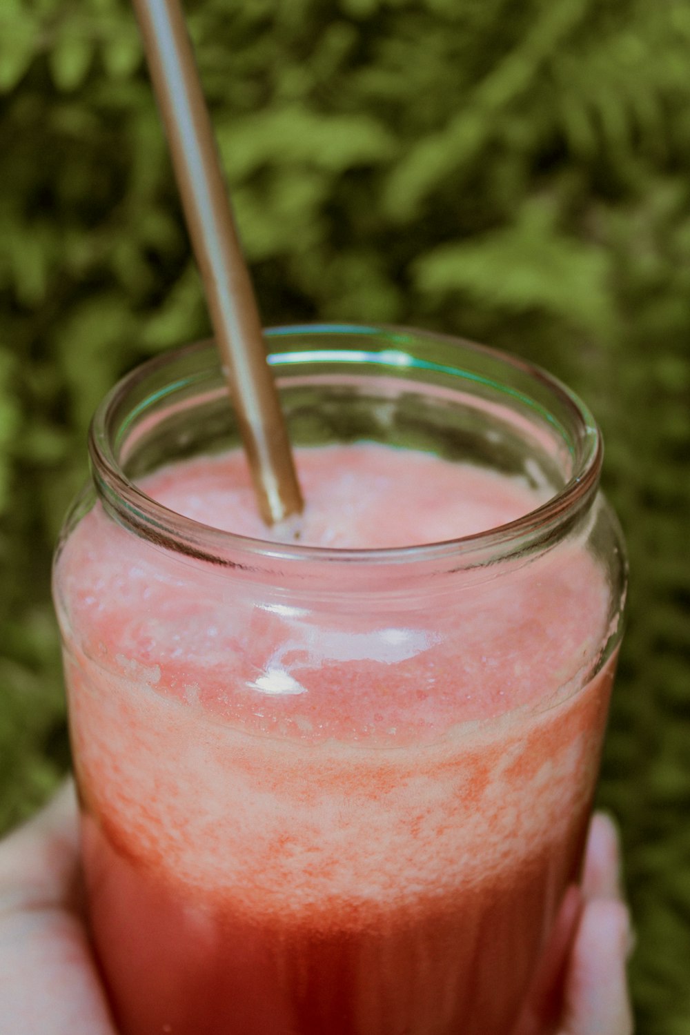 a person holding a glass with a straw in it