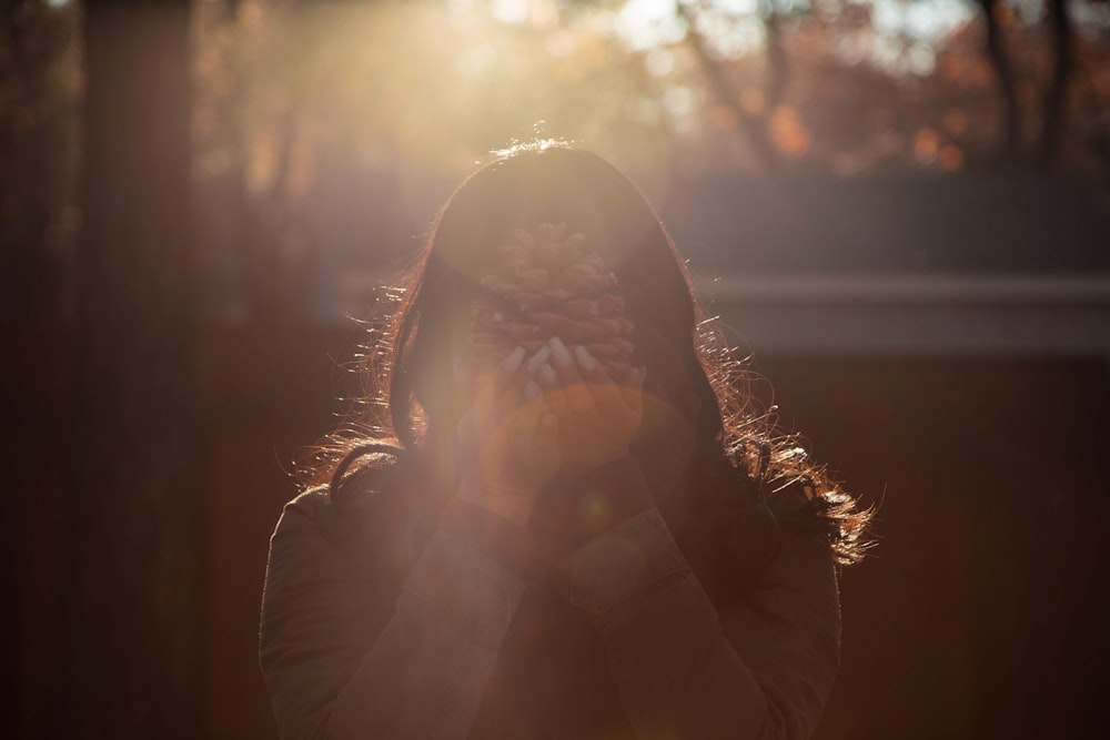 woman holding pine cone