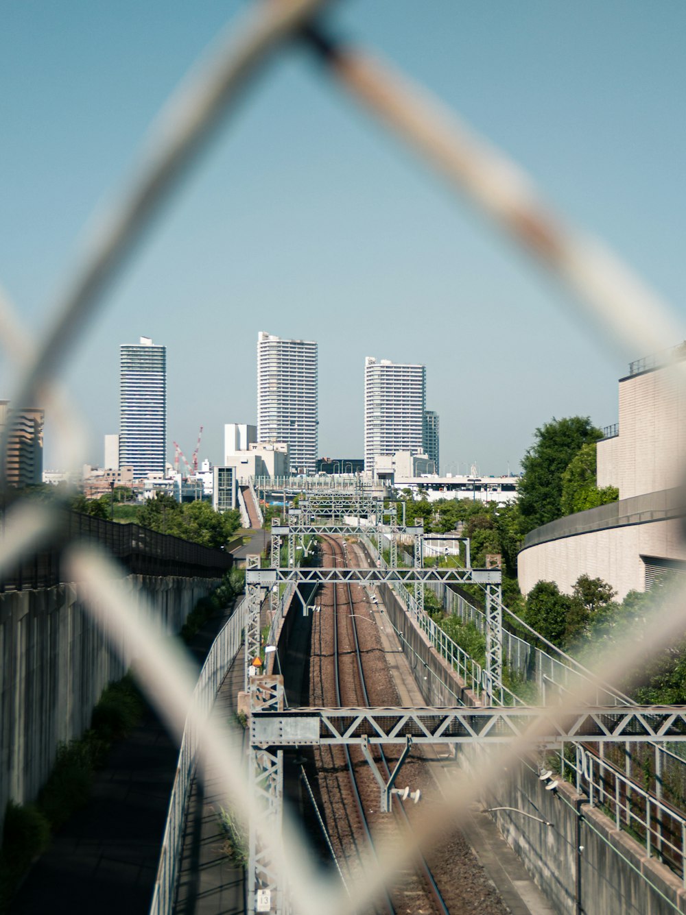 a view of a train track through a fence