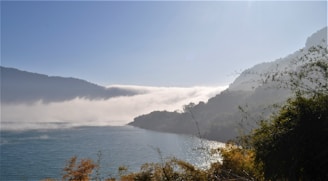 A peaceful sunrise over a serene lake surrounded by gentle hills.