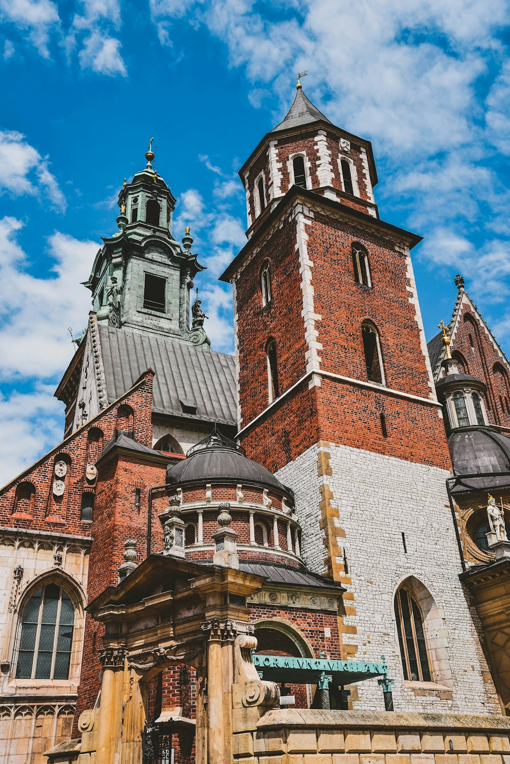 brown and gray tower under white clouds and blue sky