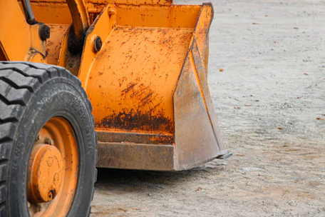 Close-up of a heavy equipment bucket undergoing structural crack reinforcement welding.