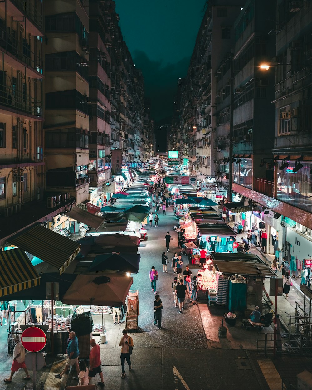 야간에 건물 근처 도로를 걷는 사람들