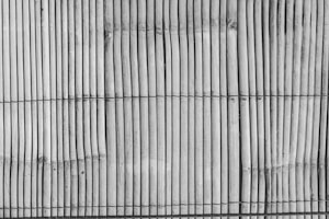 Vertical bamboo sticks are tightly bound together with horizontal black threads, creating a textured and natural pattern.