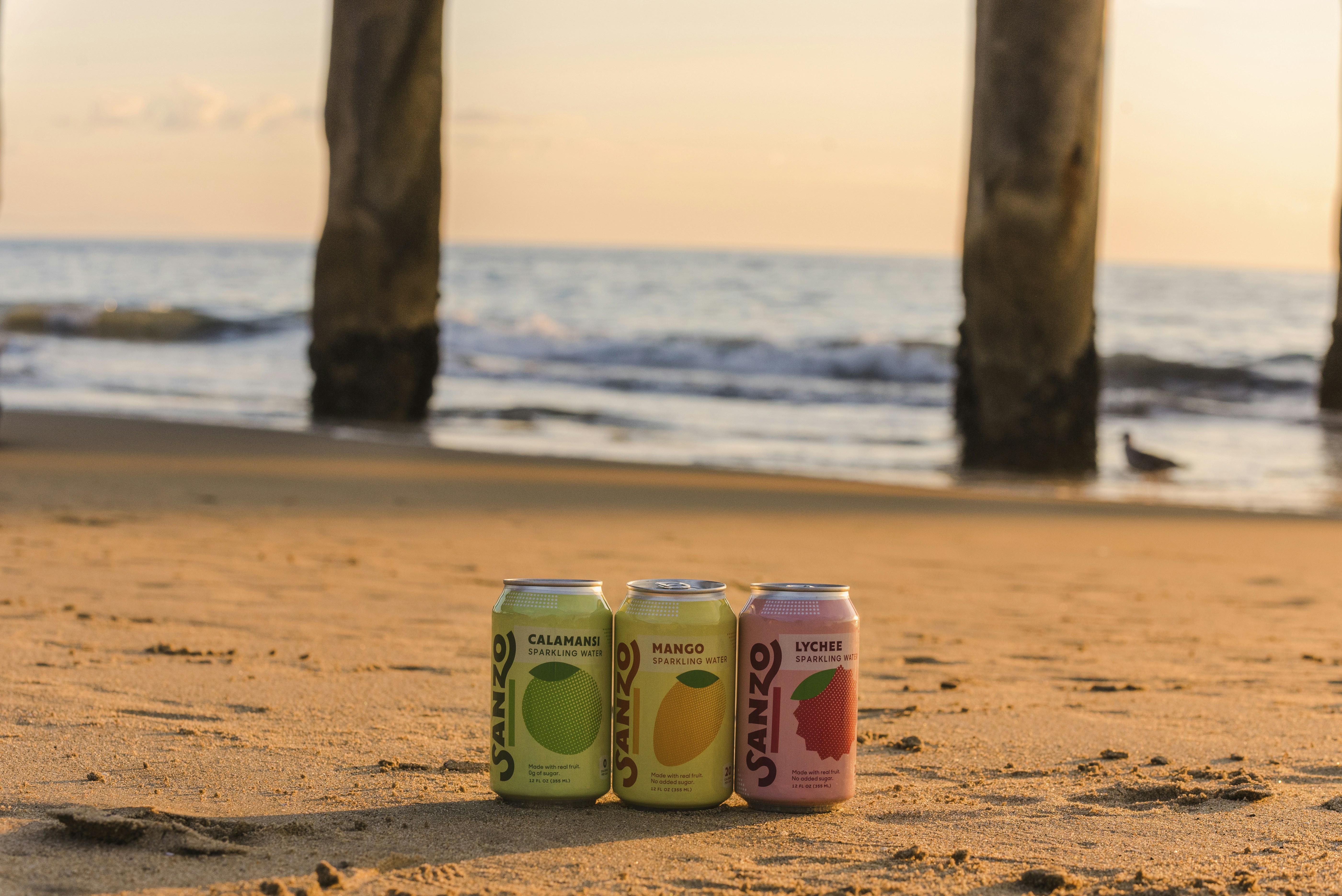 Sanzo sparkling water cans, calamansi, lychee, alphonso mango on the beach of Santa Monica, Los Angeles, California