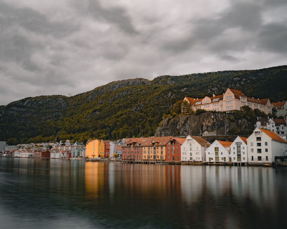 white and brown house beside calm body of water