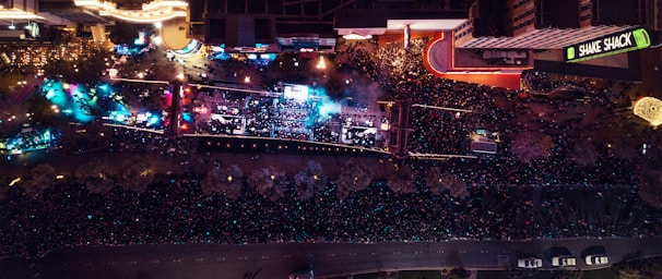 An aerial view of a large festival with crowds and food stalls.