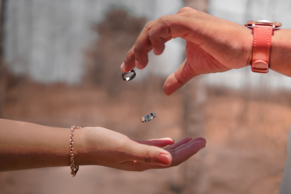 hands handing rings on persons hand