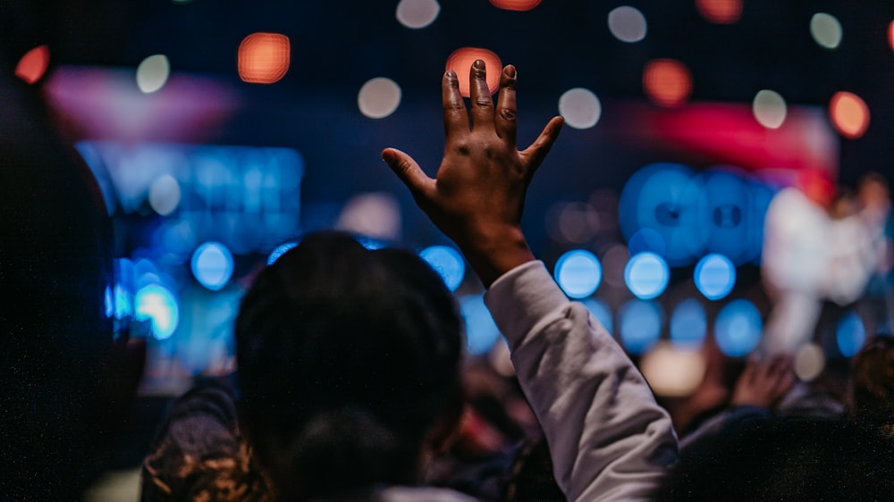 a crowd of people raising their hands in the air