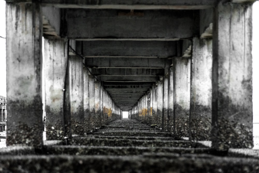 grayscale photography of concrete bridge posts