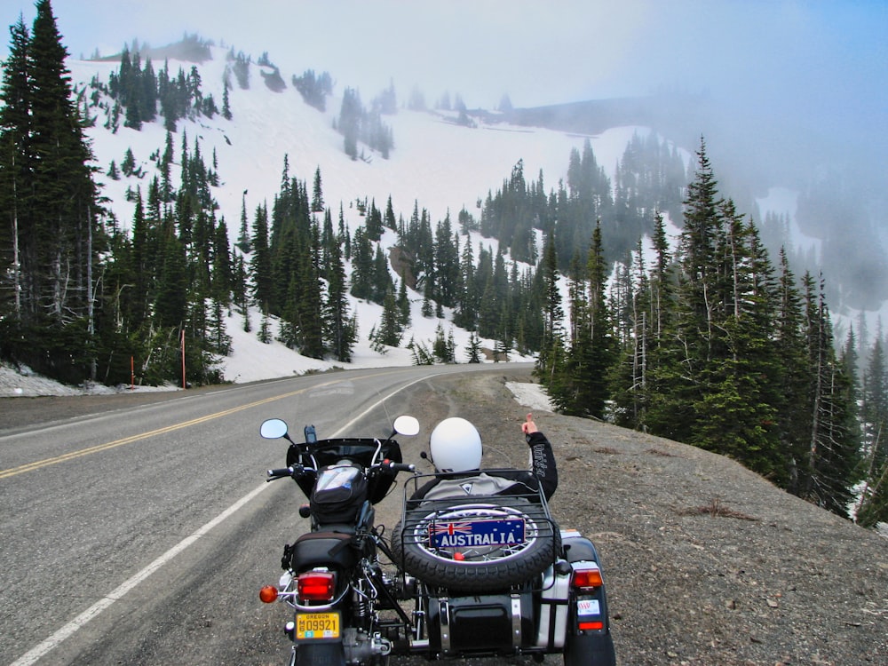 parked black motorcycle with sidecar beside road