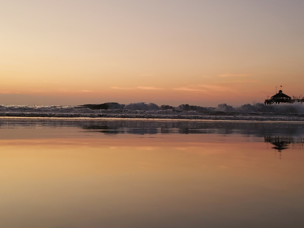 body of water under orange and gray sky