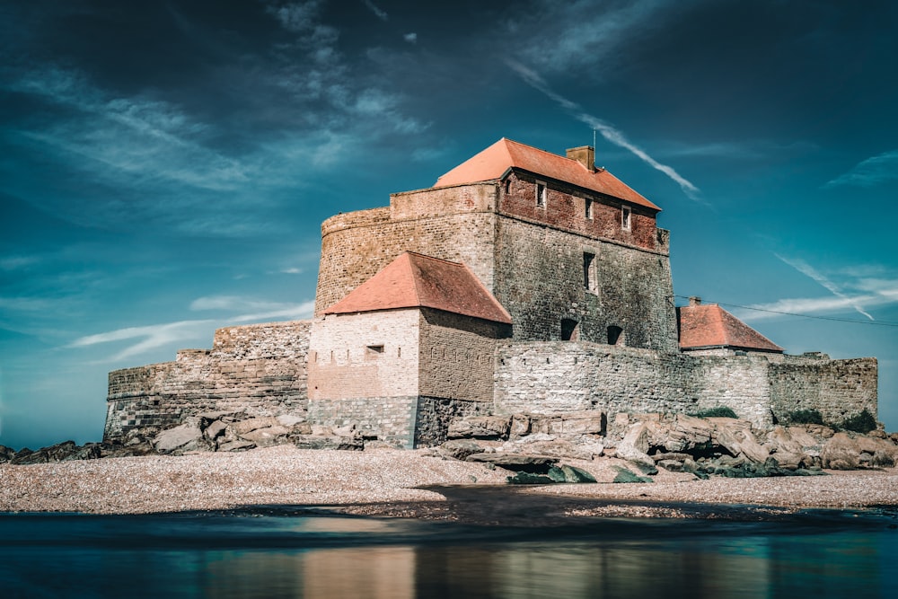 monastery in Ambleteuse, France near body of water under blue and white sky