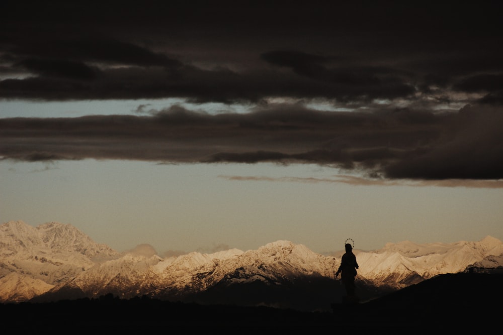 person standing near desert under gray sky