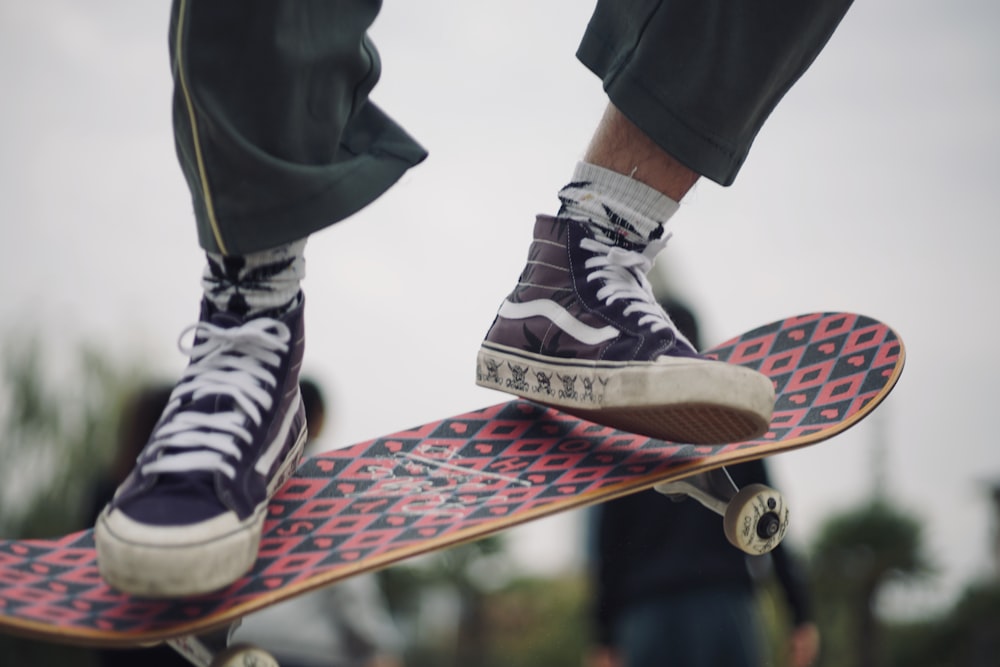 person wearing black-and-white Vans high-top shoes skateboarding