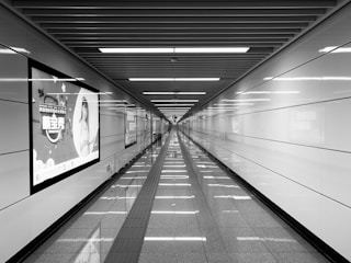 grayscale photography of tiled hallway of building