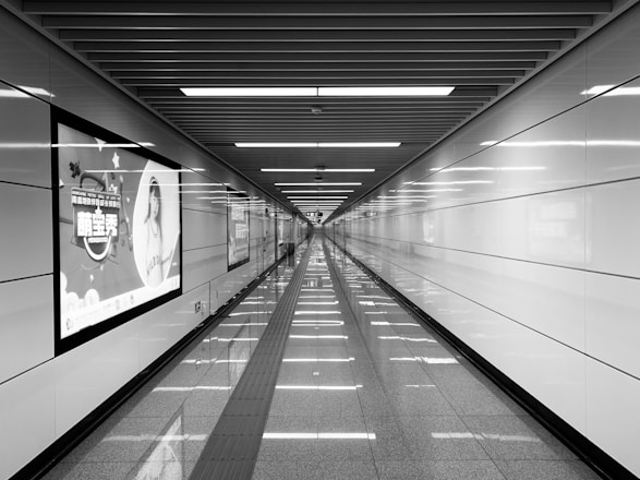 grayscale photography of tiled hallway of building