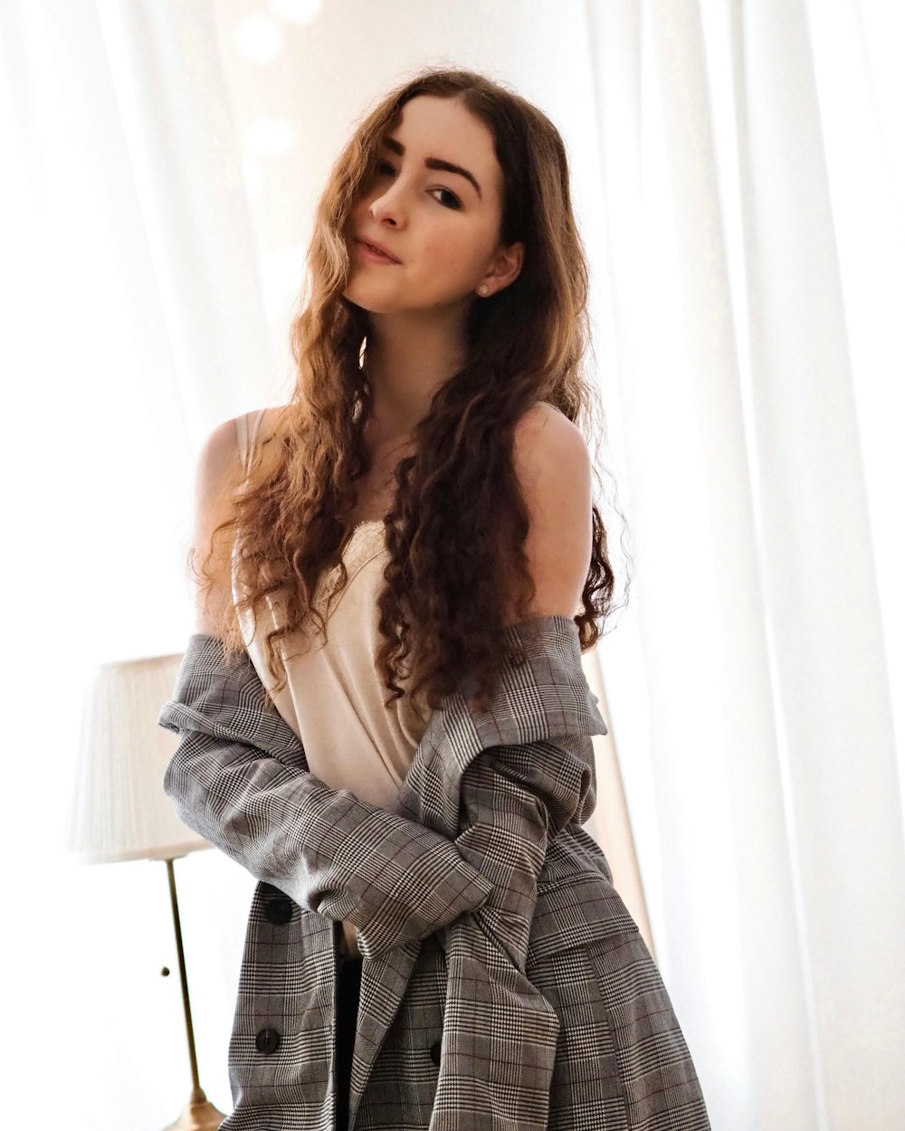 selective focus photography of standing woman beside table lamp